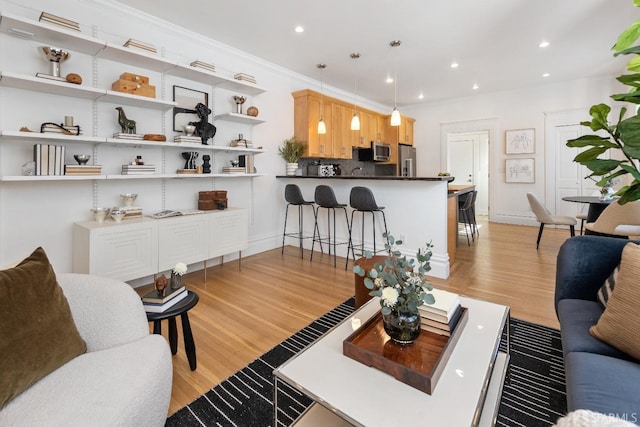 living room with crown molding and light wood-type flooring