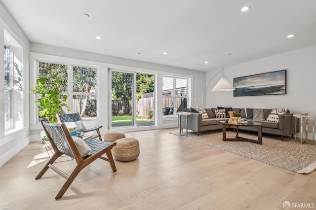 living room with a wealth of natural light, light wood-style floors, and recessed lighting