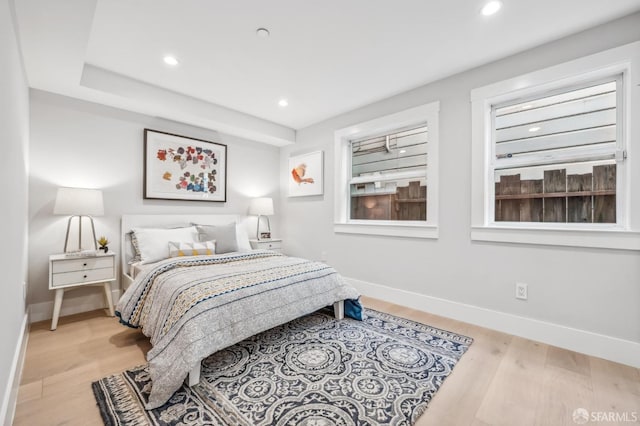 bedroom with light wood finished floors and baseboards