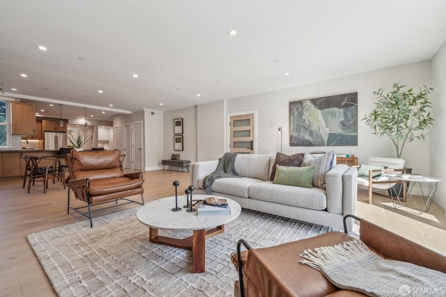 living area with light wood-style flooring, recessed lighting, and baseboards