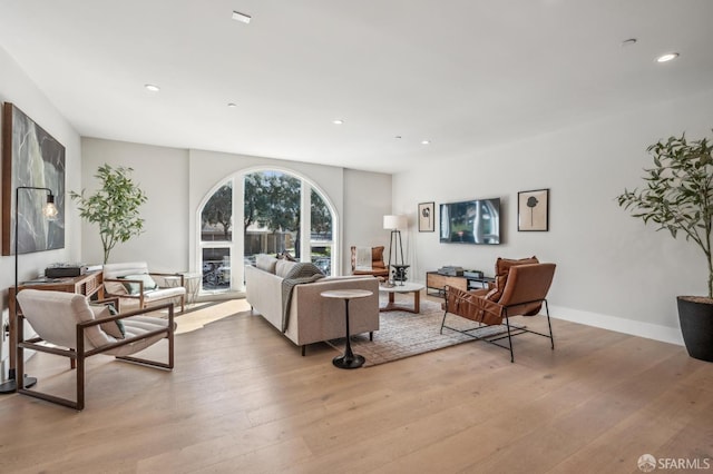 living room with recessed lighting, baseboards, and wood finished floors