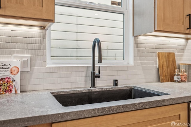 details with a sink, decorative backsplash, and stone countertops