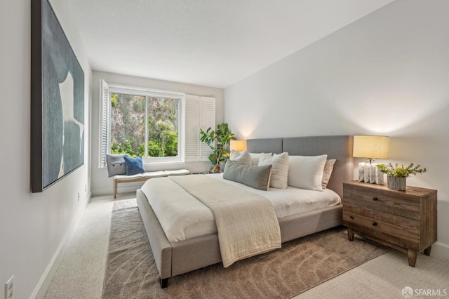 bedroom with baseboards and carpet