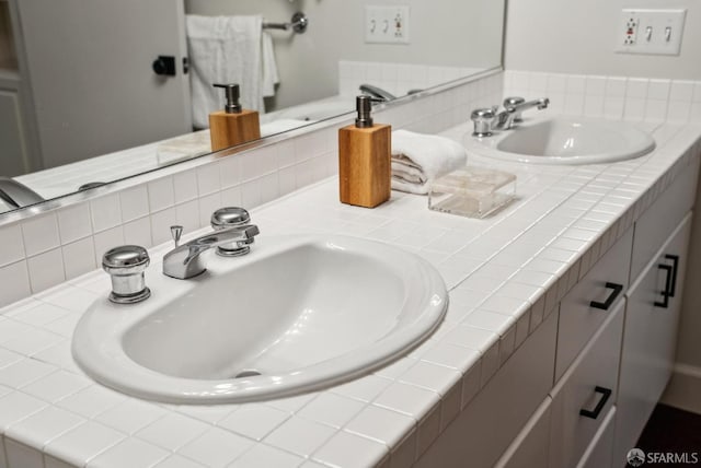full bath with double vanity, a sink, and tasteful backsplash