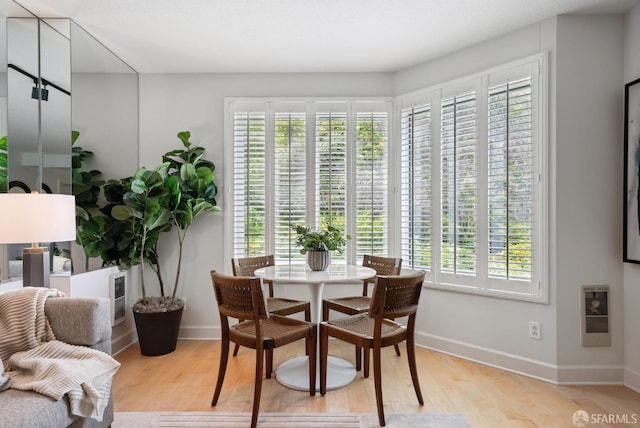 dining space featuring light wood-style floors and baseboards