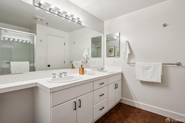 full bathroom featuring double vanity, a sink, and a stall shower