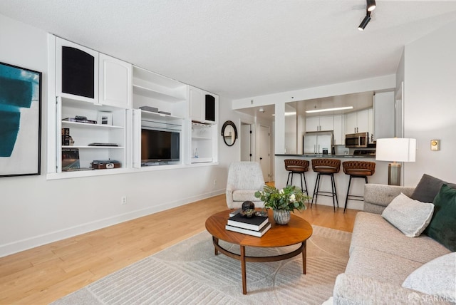 living room featuring baseboards and light wood-style flooring