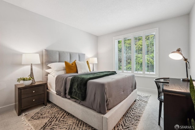 bedroom with baseboards and light carpet