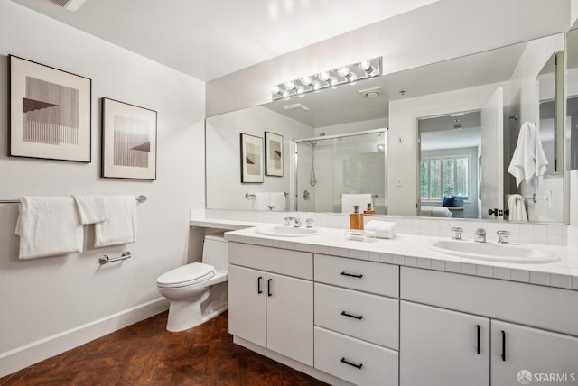 full bath featuring double vanity, a sink, a stall shower, and toilet