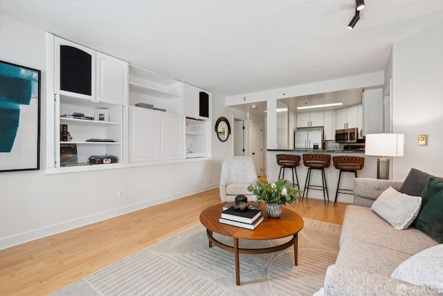 living room with baseboards and light wood-type flooring