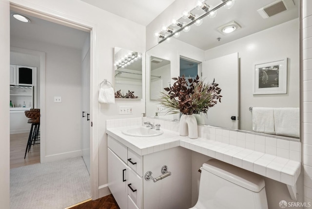 bathroom with visible vents, wood finished floors, toilet, and vanity