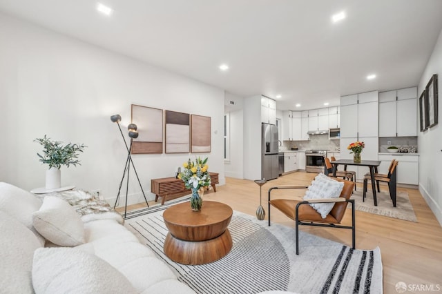 living area with light wood-type flooring, baseboards, and recessed lighting