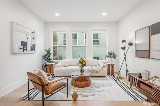 living area featuring baseboards, recessed lighting, and light wood-style floors