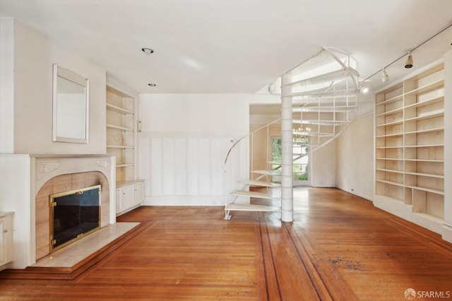 199 Edgewood Ave, San Francisco, CA 94117 - unfurnished living room with a tiled fireplace, light wood-style flooring, built in features, and stairway
