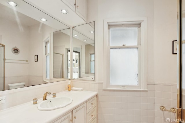199 Edgewood Ave, San Francisco, CA 94117 - bathroom featuring vanity, toilet, tile walls, and a wealth of natural light