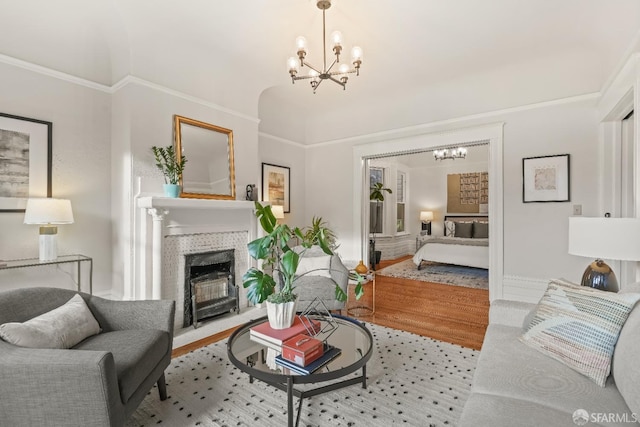 living area featuring a chandelier, a fireplace with flush hearth, and wood finished floors