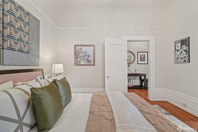 bedroom featuring baseboards and wood finished floors