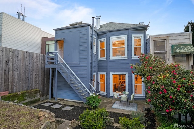 rear view of house with fence, stairway, and a patio