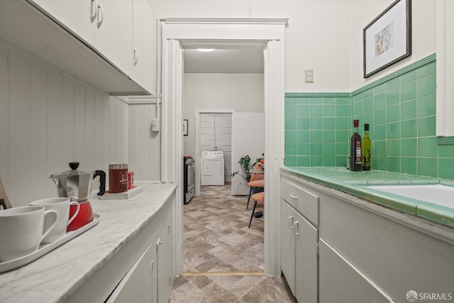 bathroom with wainscoting, vanity, and independent washer and dryer