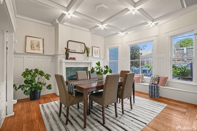 dining room featuring a fireplace, coffered ceiling, wood finished floors, and beamed ceiling