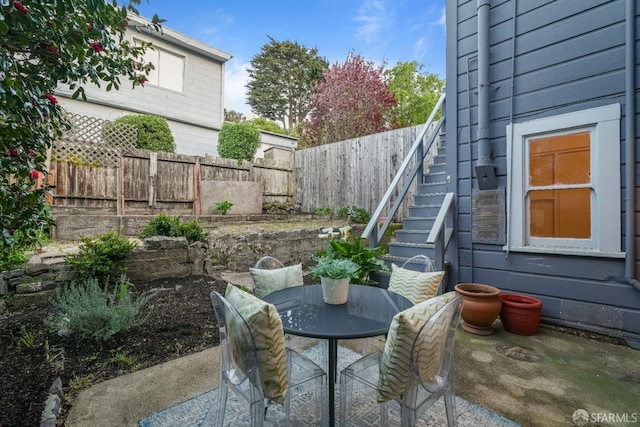 view of patio / terrace with fence and stairs