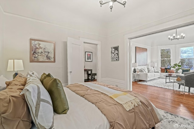 bedroom featuring wood finished floors and an inviting chandelier