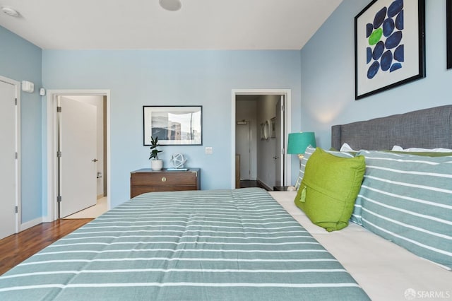 bedroom featuring hardwood / wood-style flooring and ensuite bath