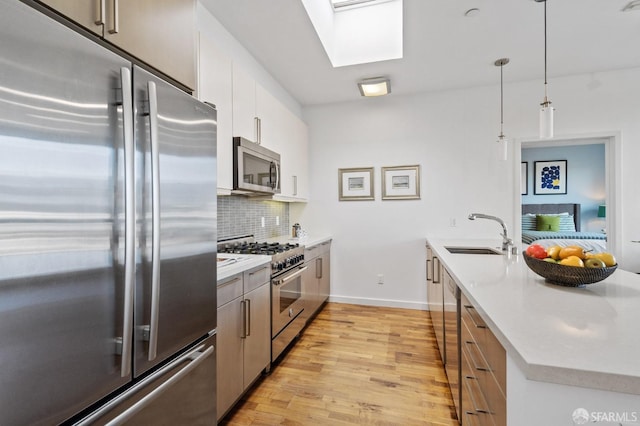 kitchen featuring appliances with stainless steel finishes, decorative light fixtures, sink, white cabinetry, and decorative backsplash