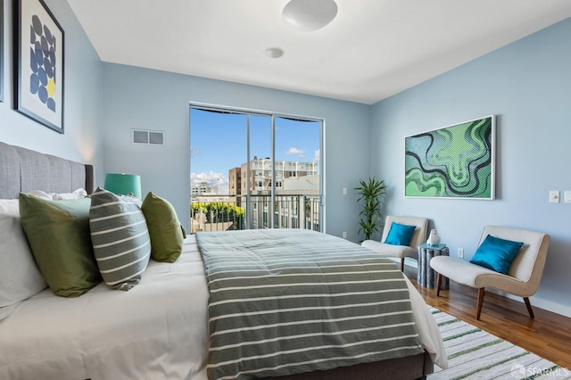 bedroom featuring access to exterior and wood-type flooring