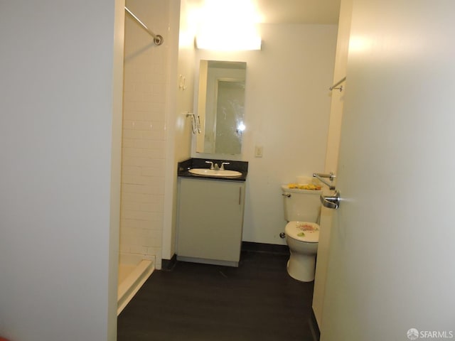 bathroom featuring walk in shower, vanity, toilet, and hardwood / wood-style floors