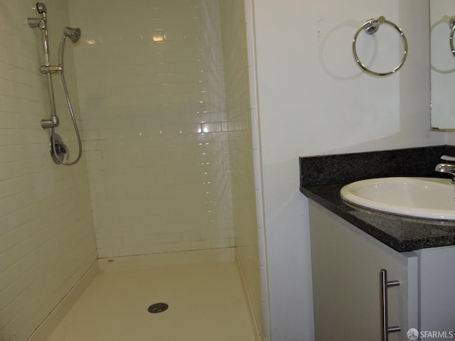 bathroom featuring vanity and tiled shower