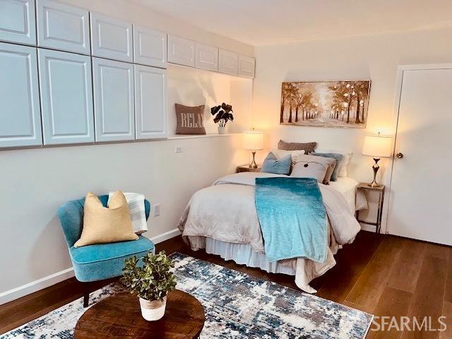 bedroom with dark wood-type flooring