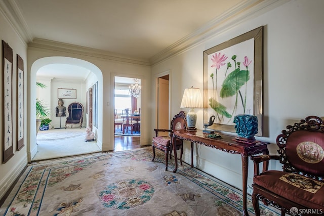 foyer entrance featuring arched walkways, baseboards, and crown molding