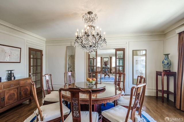 dining area featuring ornamental molding, a chandelier, a decorative wall, and wood finished floors