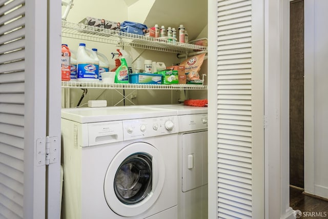 clothes washing area featuring laundry area, dark wood-type flooring, and washing machine and clothes dryer