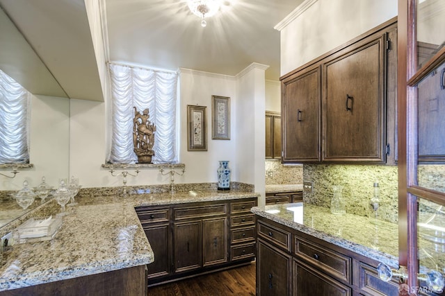 kitchen with dark brown cabinets, dark wood-type flooring, light stone counters, and decorative backsplash