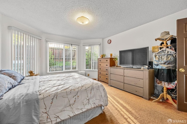 bedroom featuring a textured ceiling and light colored carpet