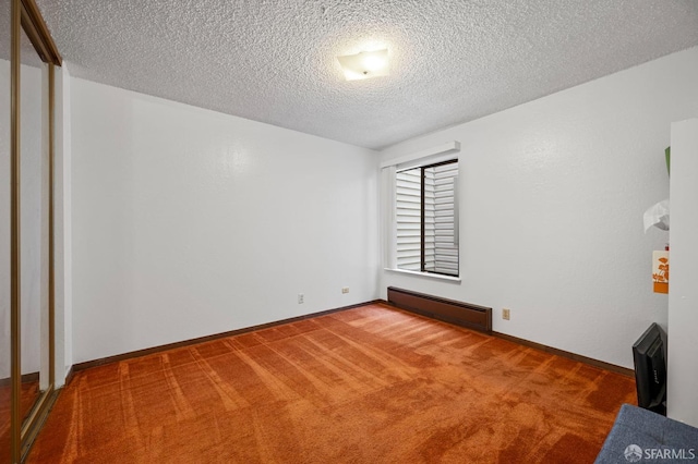 spare room featuring baseboards, a baseboard radiator, light colored carpet, and a textured ceiling