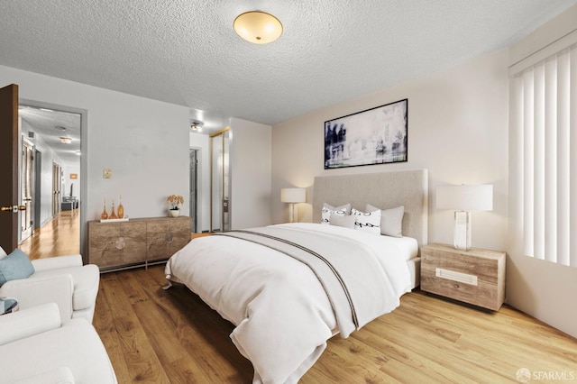 bedroom featuring a closet, wood finished floors, and a textured ceiling