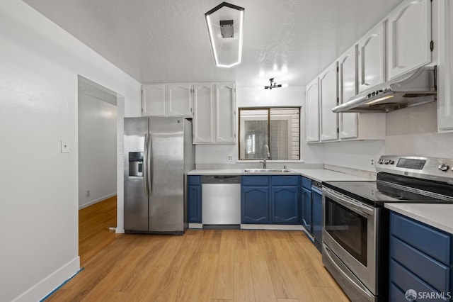 kitchen featuring a sink, appliances with stainless steel finishes, blue cabinets, and under cabinet range hood