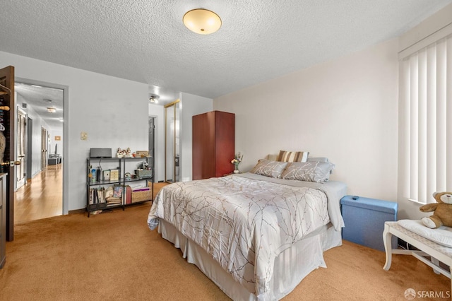 bedroom with light carpet and a textured ceiling