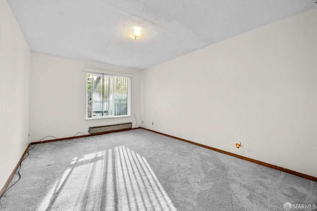 empty room featuring carpet floors, a baseboard radiator, baseboards, and a textured ceiling