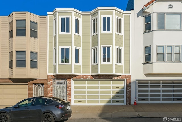 multi unit property featuring an attached garage and brick siding