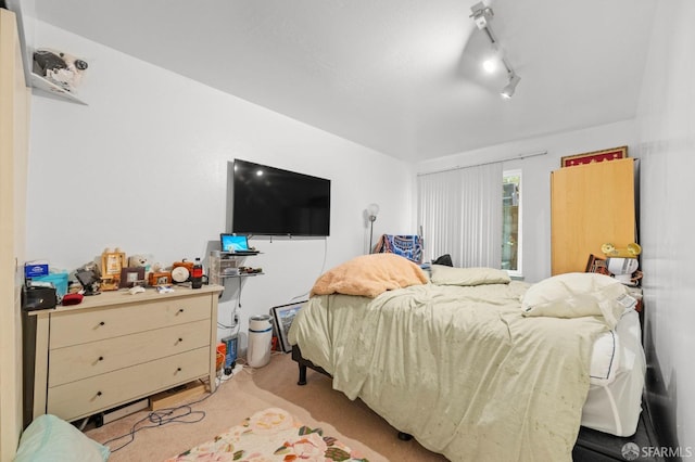 carpeted bedroom featuring rail lighting
