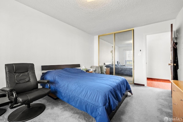 carpeted bedroom with a closet and a textured ceiling