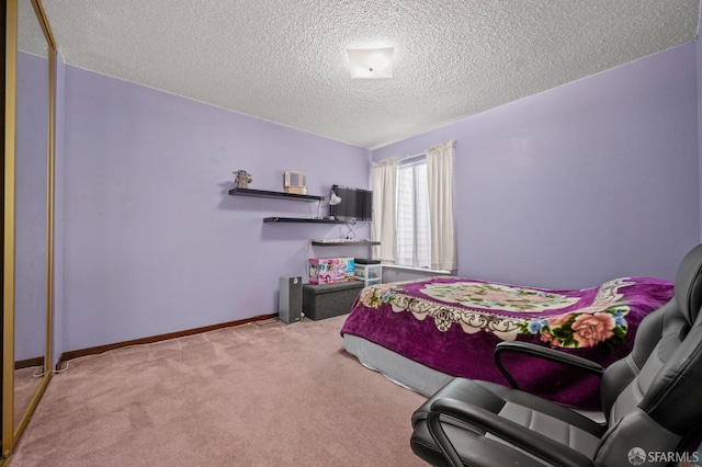 carpeted bedroom featuring baseboards and a textured ceiling