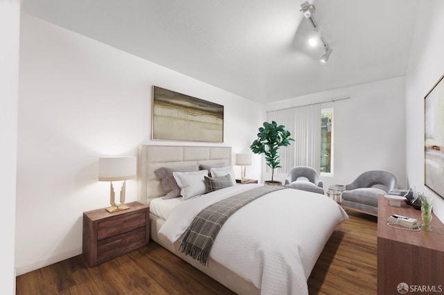 bedroom featuring track lighting, baseboards, and wood finished floors