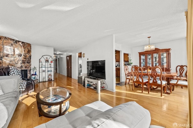 living area featuring a notable chandelier, wood finished floors, and a textured ceiling