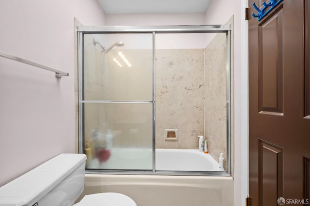 bathroom featuring toilet and combined bath / shower with glass door