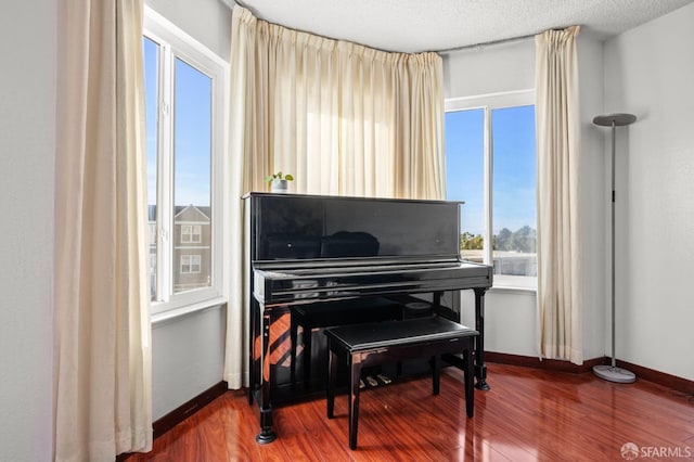 sitting room with plenty of natural light, baseboards, and wood finished floors